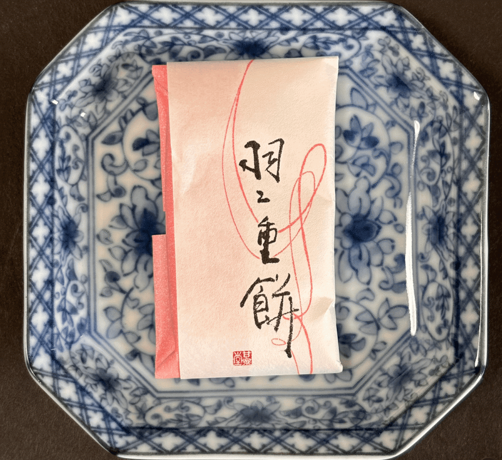 青い八角皿にのせた、村中甘泉堂の羽二重餅の個包装